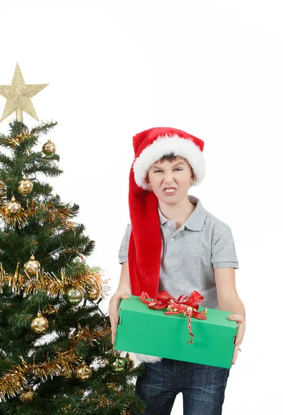 Happy boy in santa hat surprised by christmas present — Stock Photo, Image