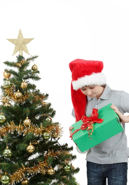 Lycklig pojke i santa hatt överraskad av julklapp — Stockfoto