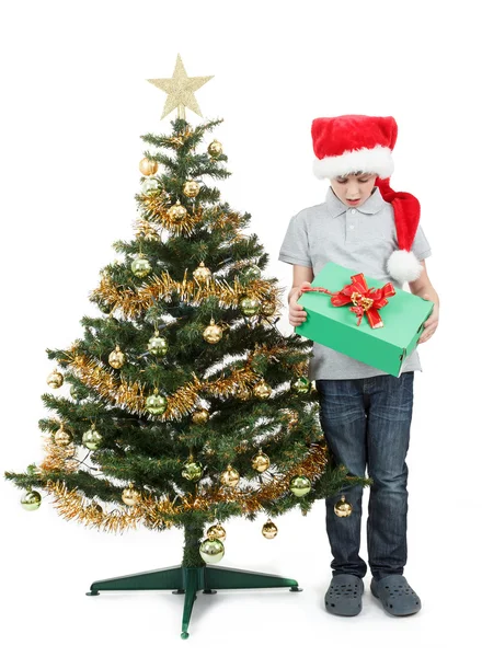 Lycklig pojke i santa hatt överraskad av julklapp — Stockfoto