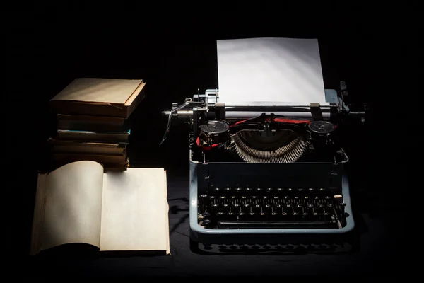 Máquina de escribir retro con pila de libro y un libro abierto —  Fotos de Stock