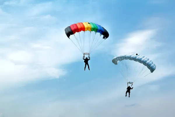 Oidentifierade fallskärmshoppare på blå himmel — Stockfoto