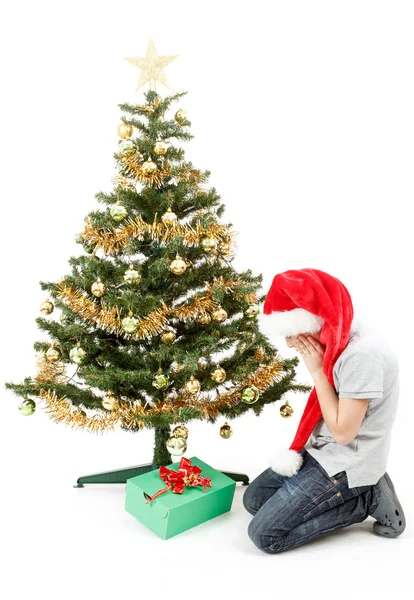 Happy boy in santa hat surprised by christmas present — Stockfoto