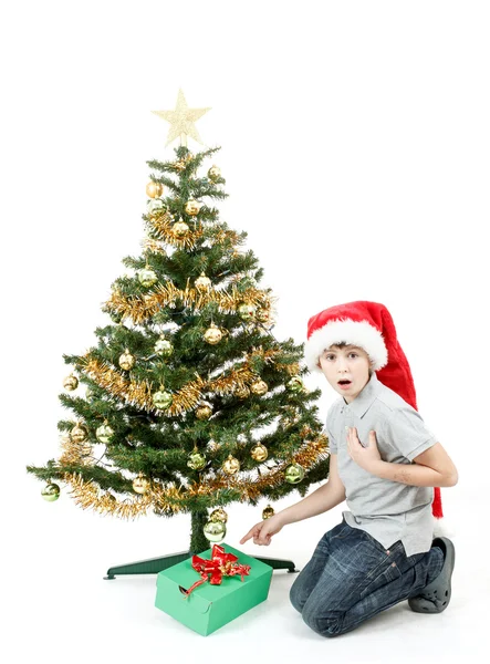 Lycklig pojke i santa hatt överraskad av julklapp — Stockfoto