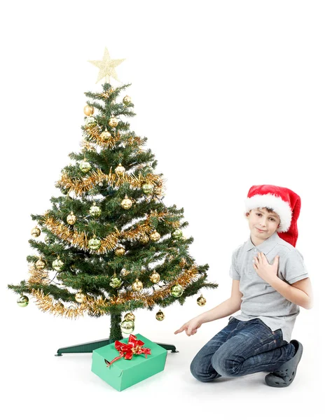 Lycklig pojke i santa hatt överraskad av julklapp — Stockfoto