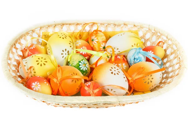 Painted easter eggs with ribbon in basket on white — Stock Photo, Image