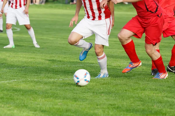 Pernas jogador de futebol driblando em um jogo — Fotografia de Stock