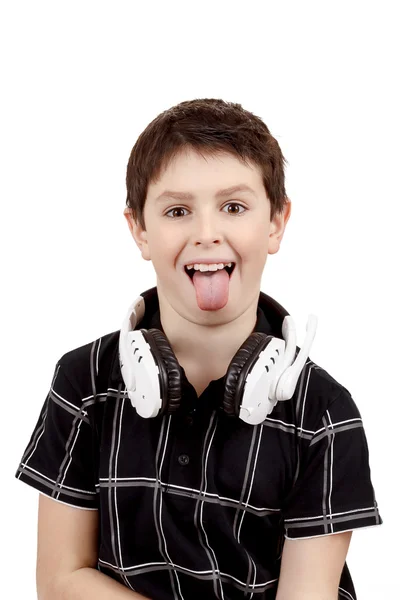 Joven niño sonriendo y mostrar la lengua con auriculares —  Fotos de Stock