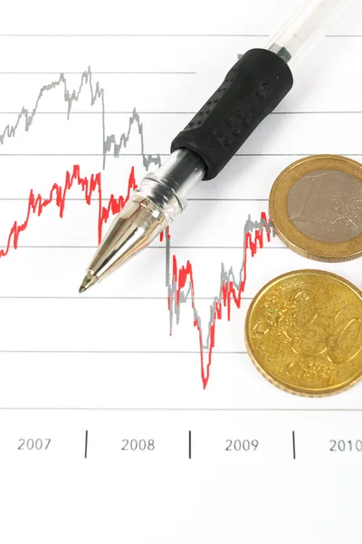 Графики фондового рынка с ручкой и монетами евро — стоковое фото