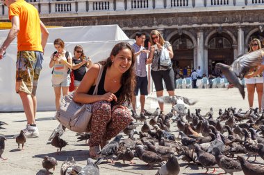 İtalya, Venedik - Temmuz 2012: Venedik'teki en ünlü Meydanı 16 Temmuz 2012 tarihinde güvercinler ile kadın. 20 milyondan fazla turist her yıl Venedik'e gel.