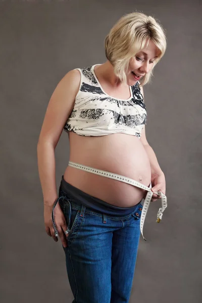 Красивая беременная женщина нежно измеряет свой живот — стоковое фото