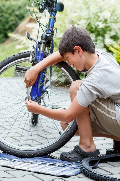 Teenager repariert sein Fahrrad, wechselt kaputten Reifen — Stockfoto