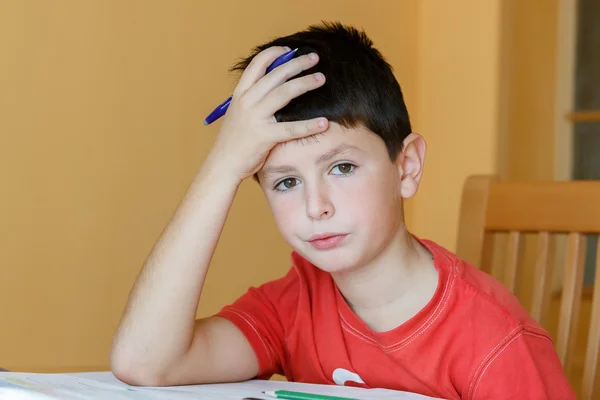 Fatigué et ennuyé garçon faire des devoirs scolaires — Photo