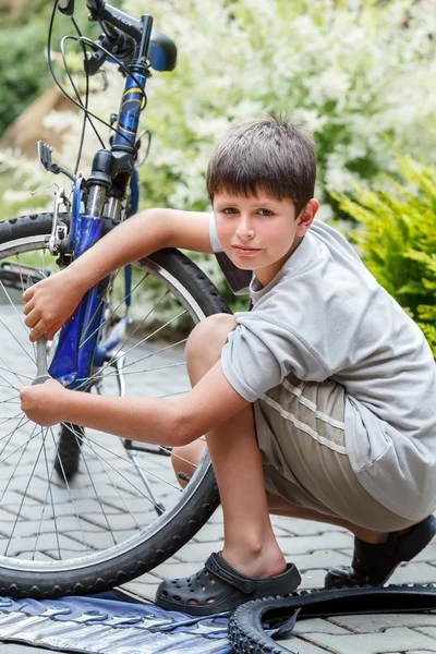 Adolescente reparando sua bicicleta, trocando pneu quebrado — Fotografia de Stock