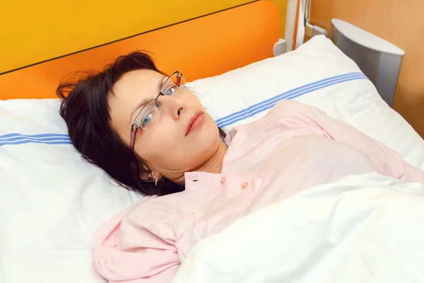 Sad middle-aged woman lying in hospital — Stock Photo, Image