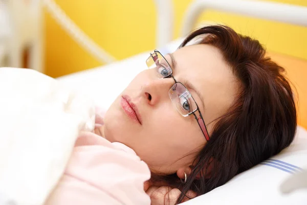 悲しい中年女性病院で横になっています。 — ストック写真