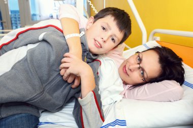 üzgün orta yaşlı bir kadın ile oğlu hastaneye yatan