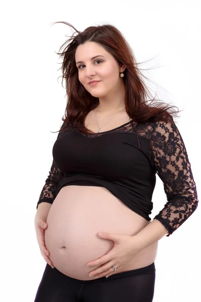 Bela mulher grávida ternamente segurando sua barriga isolada no fundo branco — Fotografia de Stock