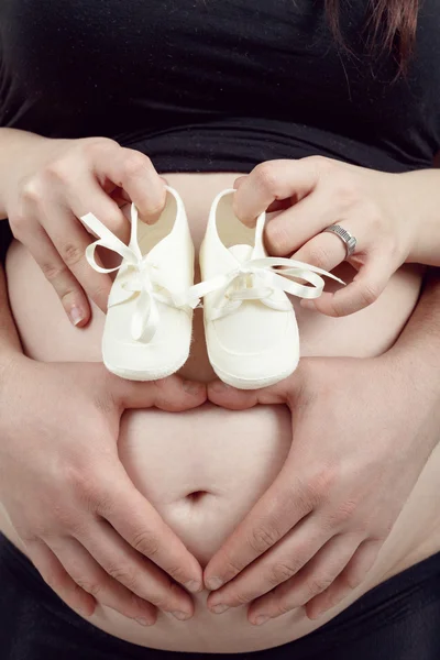 Femme enceinte avec une chaussure d'enfant — Photo