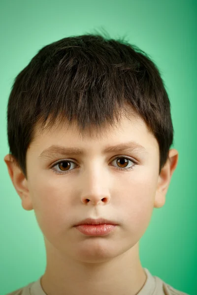Студийный портрет мальчика на зеленом фоне — стоковое фото
