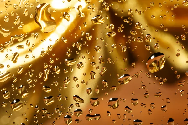 Fundo abstrato dourado com gotas de água — Fotografia de Stock