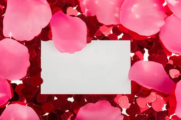 Küçük konfeti kırmızı ve beyaz arka plan üzerinde büyük yürekler — Stok fotoğraf