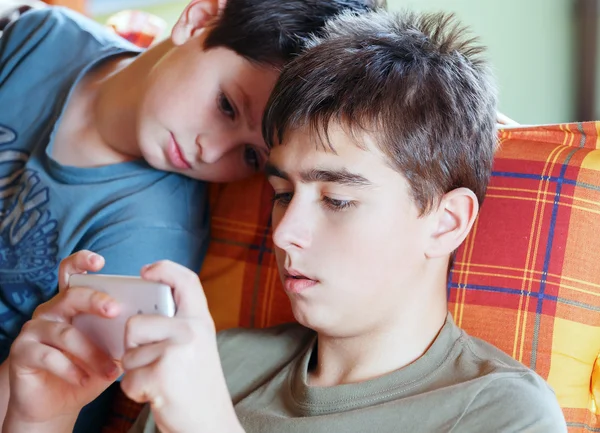 Adolescentes jugando en el teléfono inteligente, al aire libre — Foto de Stock