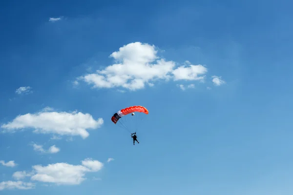 Oidentifierade fallskärmshoppare på blå himmel — Stockfoto