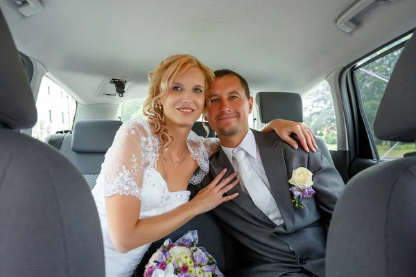 Mooie jonge bruidspaar in auto — Stockfoto