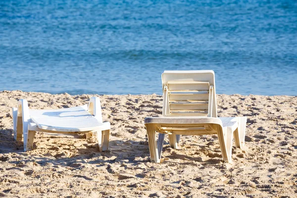 Two old sunloungers on tunisian beach — Stock Photo, Image