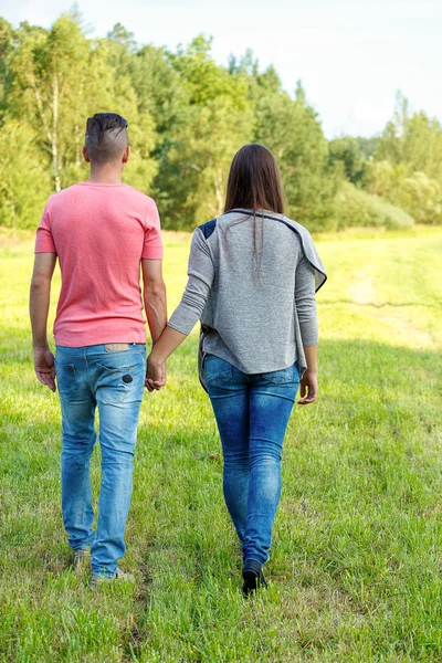 Vista posteriore della giovane coppia che cammina all'aperto — Foto Stock