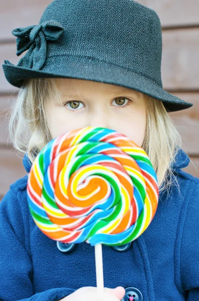 Rainbow lollypop and girl — Stock Photo, Image