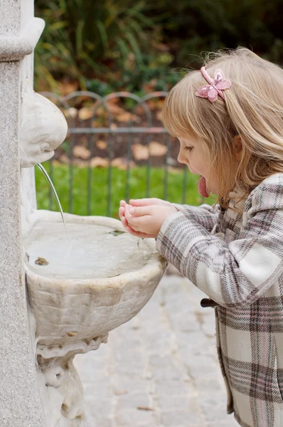 Uma menina bebendo da fonte — Fotografia de Stock