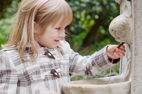 A girl and gardens fountain — Stock Photo, Image