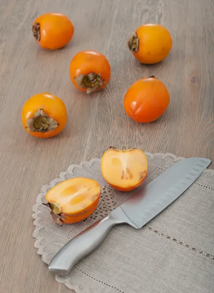 Cut persimmon fruit and knife — Stock Photo, Image