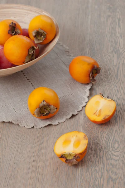 Persimmon on wooden background — Stock Photo, Image