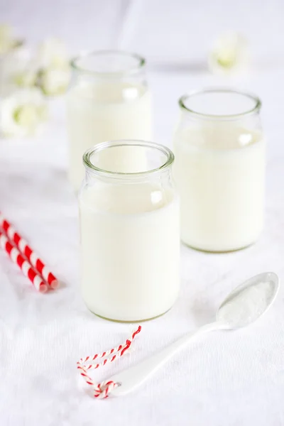 Frascos de leite com colher pequena — Fotografia de Stock