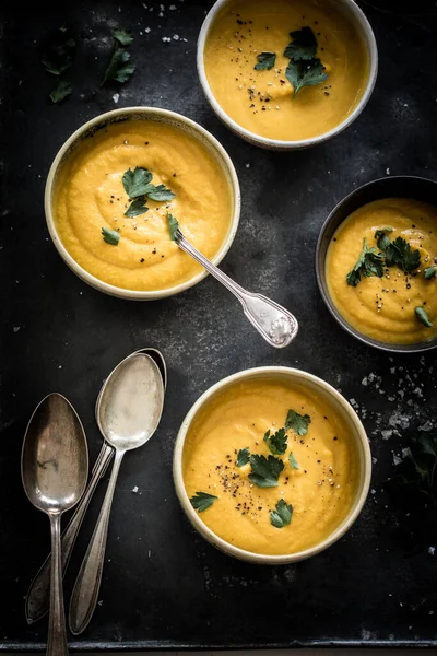 Karotten Und Pastinakensuppe Mit Frischen Kräutern Obendrauf Serviert Vier Schüsseln lizenzfreie Stockfotos