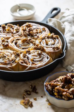 Kakule ve fındıklı tarçınlı çörek. Çörekler kremayla kaplı..