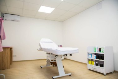 Boş beyaz şekerleme masası, sandalye, spa salonunda bir sonraki müşteri için hazır.