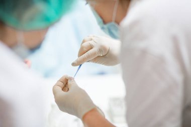 Ameliyat sırasında hastanede stomatolojik aletler tutan profesyonel dişçi.