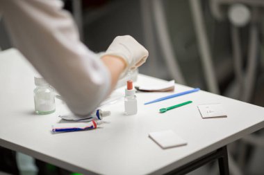 Ameliyat sırasında hastanede dişçi aletleriyle birlikte masanın yanında stomatolojik aletler tutan profesyonel bir dişçi.