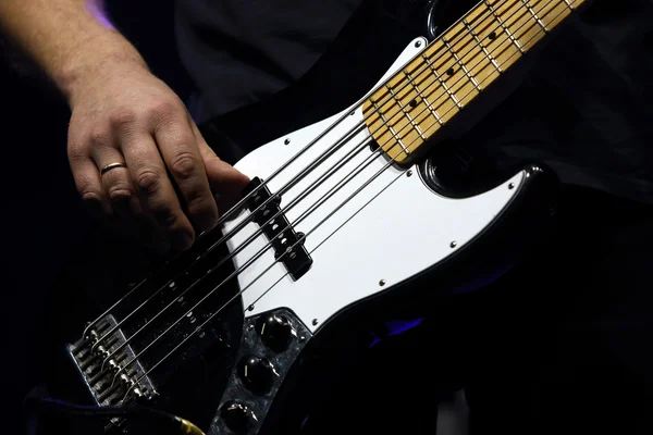 The guitarist plays bass guitar during a rock concert — Stock Photo, Image