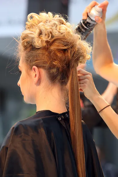 Fryzjer Czesanie włosów młodej dziewczyny za pomocą lakier do włosów — Zdjęcie stockowe