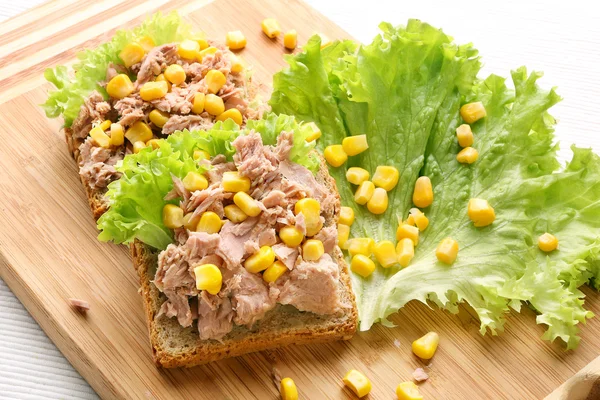 Сэндвич с тунцом и кукурузой на деревянном фоне — стоковое фото