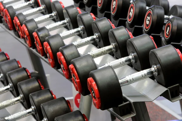 Sombrillas pesas alineadas en un gimnasio — Foto de Stock