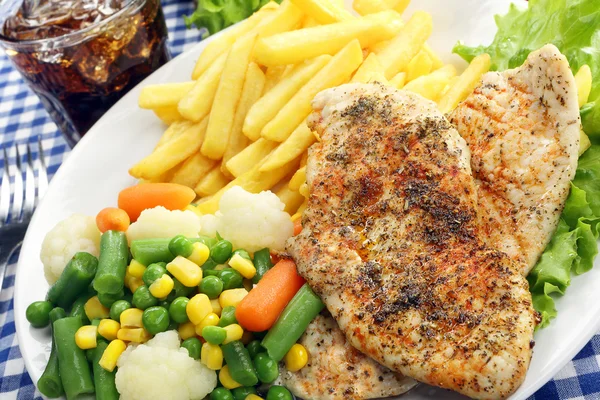 Filet de poulet grillé aux herbes avec légumes frais et frites — Photo