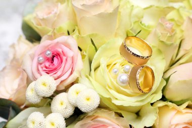 Altın alyans üzerine gül buketi