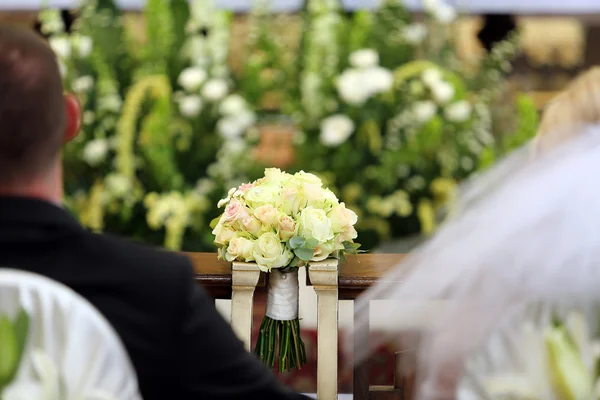 Bruids bruiloft boeket liggend op de hassock tijdens het huwelijk — Stockfoto