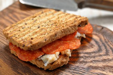 Ahşap arka planda domuz yağı ve pepperoni salamlı çıtır tost ve metin için boş alan