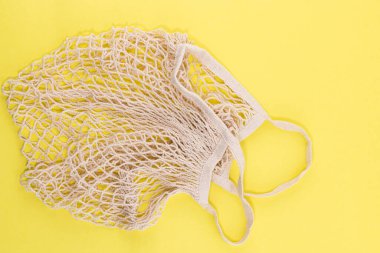 Yeniden kullanılabilir pamuk ve ağlı eko poşetler. Fotokopi alanı olan sarı arka planda alışveriş yapmak için. Sıfır atık. Plastik yok.